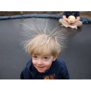  A Young Male Plays on a Trampoline Which Causes His Hair 