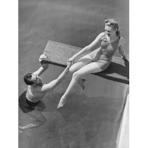  Woman Sitting on Diving Board, Man Grasping Her Hand 